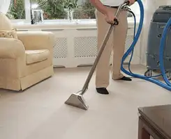 Carpet cleaning professional removing dirt and stains with a hot-water extraction tool in a home, Dayton, OH.